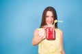 Beautiful young woman holding strawberry smoothie on blue background. Healthy organic drinks concept. People on a diet. Royalty Free Stock Photo