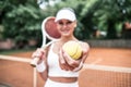 Beautiful young woman holding tennis racket and looking happy Royalty Free Stock Photo