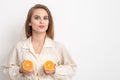 Beautiful young woman holding two half pieces of orange Royalty Free Stock Photo