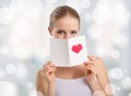 Beautiful young woman holding a valentine postcard