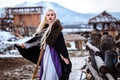 Beautiful young woman holding a viking with blond hair. Image of Historical figure Royalty Free Stock Photo