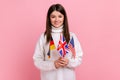 Beautiful young woman holds in hands British, German and American flags, polyglot studying languages