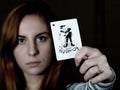 Beautiful young woman holds a playing card joker Royalty Free Stock Photo