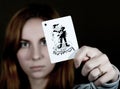 Beautiful young woman holds a playing card joker Royalty Free Stock Photo