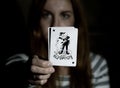 Beautiful young woman holds a playing card joker Royalty Free Stock Photo