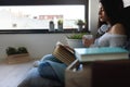 Beautiful young woman at home drinking coffee reading a book Royalty Free Stock Photo