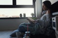 Beautiful young woman at home drinking coffee reading a book Royalty Free Stock Photo