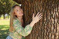 Beautiful woman hugging tree trunk in forest Royalty Free Stock Photo