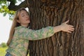 Beautiful young woman hugging tree trunk Royalty Free Stock Photo