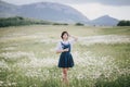 Beautiful young woman in a jeans dress and straw hat posing in a camomile field Royalty Free Stock Photo