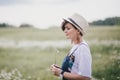 Beautiful young woman in a jeans dress and straw hat posing in a camomile field Royalty Free Stock Photo