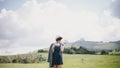 Beautiful young woman in a jeans dress and straw hat posing on a green meadow Royalty Free Stock Photo