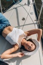 beautiful young woman in jeans and a hat lies on a yacht Royalty Free Stock Photo