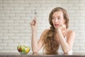 Beautiful young woman in joyful postures with salad bowl