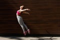 Beautiful young woman jumping against wooden wall Royalty Free Stock Photo