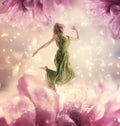 Beautiful young woman jumping on giant flower Royalty Free Stock Photo