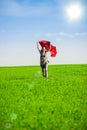 Beautiful young woman jumping on a green meadow with colored tissue Royalty Free Stock Photo