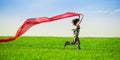 Beautiful young woman jumping on a green meadow with colored tissue Royalty Free Stock Photo