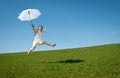 Beautiful young woman jumping with white umbrella