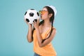 Beautiful young woman kissing a football Royalty Free Stock Photo