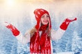 Beautiful young woman in a beautiful knitted hat, mitten and scarf walks in the winter forest.Fashionable knitted clothes. Royalty Free Stock Photo