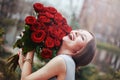 Beautiful young woman with a large bouquet of flowers