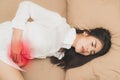 Beautiful young woman laying on the bed suffering from abdominal pain. female suffering from period on the bed Royalty Free Stock Photo