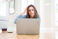 Beautiful young woman laying on the floor using laptop annoyed and frustrated shouting with anger, crazy and yelling with raised Royalty Free Stock Photo