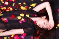 Beautiful young woman laying on sparse rose petals Royalty Free Stock Photo