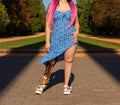 Beautiful young woman leg amputee in a dress walking in park at sunny day Royalty Free Stock Photo