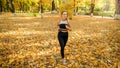 Beautiful young woman in leggings running and trainin in autumn park Royalty Free Stock Photo