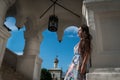 Beautiful young woman in light dress stands at the entrance of the church Royalty Free Stock Photo