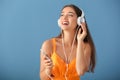 Beautiful young woman listening to music on color background Royalty Free Stock Photo