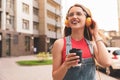 Beautiful young woman listening to music with headphones on sunny day outdoors Royalty Free Stock Photo