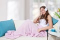 Beautiful young woman listening to music on the sofa