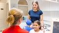 Beautiful young woman with little daughter visiting dentist office