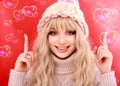 Beautiful young woman with long blond curly hair, dressed in a pink knitted sweater and hat. Beauty, fashion. Royalty Free Stock Photo