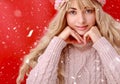 Beautiful young woman with long blond curly hair, dressed in a pink knitted sweater and hat. Beauty, fashion. Royalty Free Stock Photo