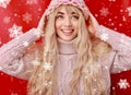 Beautiful young woman with long blond curly hair, dressed in a pink knitted sweater and hat. Beauty, fashion. Royalty Free Stock Photo