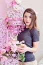 Beautiful young woman with long blonde hair, blue eyes, flowering cage, wearing t-shirt. Royalty Free Stock Photo