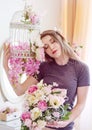 Beautiful young woman with long blonde hair, blue eyes, flowering cage, wearing t-shirt. Royalty Free Stock Photo