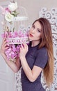 Beautiful young woman with long blonde hair, blue eyes, flowering cage, wearing t-shirt. Royalty Free Stock Photo