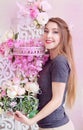 Beautiful young woman with long blonde hair, blue eyes, flowering cage, wearing t-shirt. Royalty Free Stock Photo