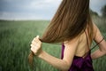 Beautiful young woman with long blonde hair in motion turned back, on the green field.Summer and freedom concept. Royalty Free Stock Photo