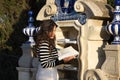 A beautiful young woman with long brown hair is browsing through a book in a public library in a city park. Concept of reading and Royalty Free Stock Photo