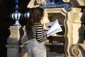 A beautiful young woman with long brown hair is browsing through a book in a public library in a city park. Concept of reading and Royalty Free Stock Photo