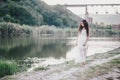 Beautiful young woman with long curly hair dressed in boho style dress posing near lake Royalty Free Stock Photo