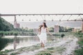 Beautiful young woman with long curly hair dressed in boho style dress posing near lake Royalty Free Stock Photo