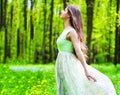 Beautiful young woman in long dress relaxing in the forest