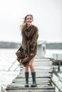 Beautiful young woman in long green dress on wooden panton by the river Royalty Free Stock Photo